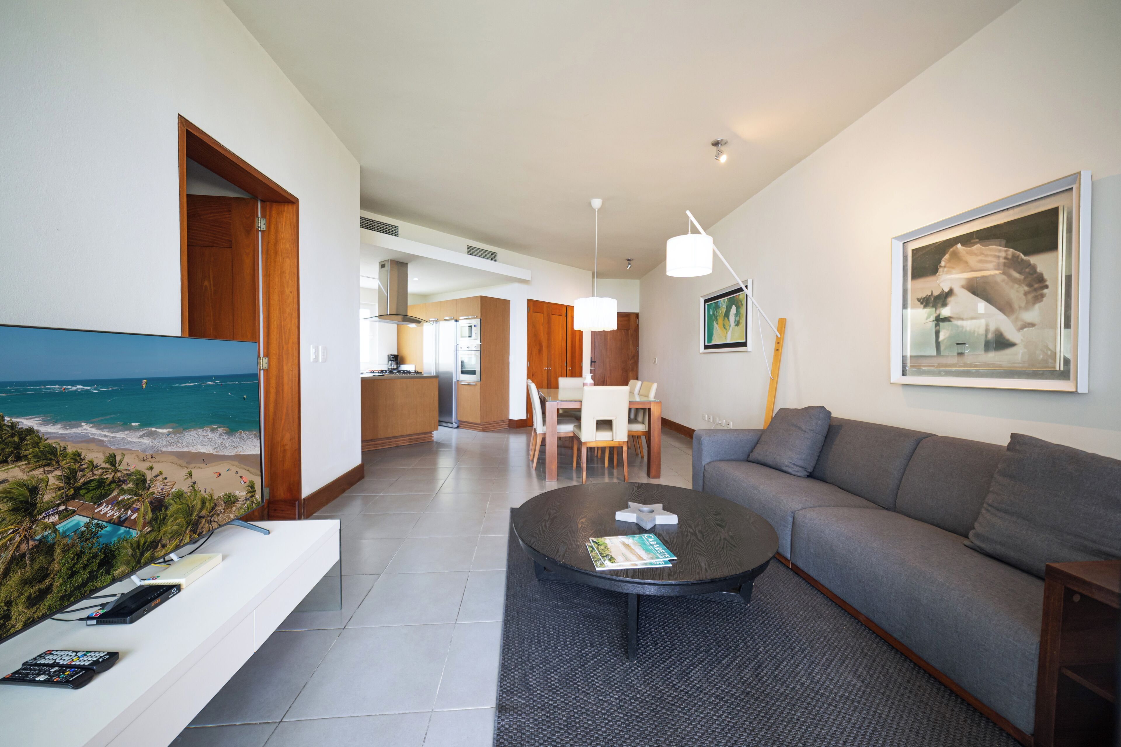 Uma sala de estar moderna com sofá, mesa de centro e obras de arte na parede.