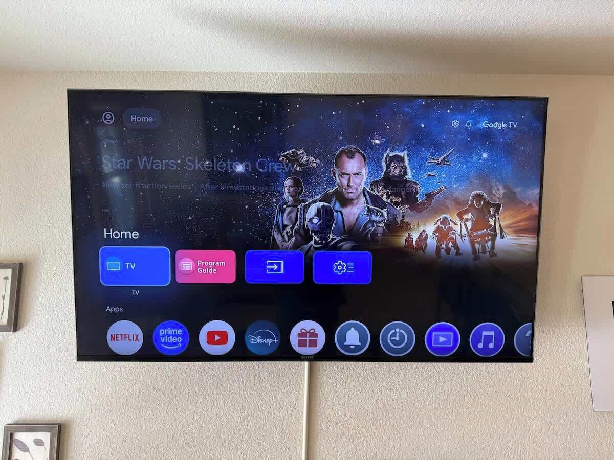 A flat-screen TV mounted on a wall displaying a Star Wars-themed interface with a navigation menu.