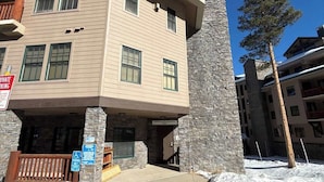 A multi-story building with a stone facade and a flat roof.
