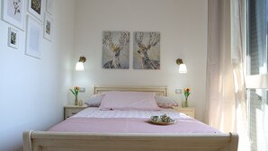 Een slaapkamer met een bed, nachtkastjes en kunst aan de muur.