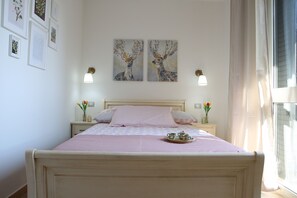 Ein Schlafzimmer mit einem Bett, Nachttischen und einem Kunstwerk an der Wand.