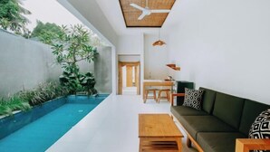 A modern living room with a pool, a ceiling fan, and a dining area. - Mahayoga Ubud Private Pool Villa Spa And Resto (Bali)