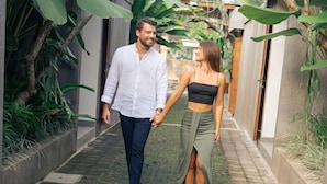 A couple walking down a narrow pathway lined with greenery and a building on one side. - Mahayoga Ubud Private Pool Villa Spa And Resto (Bali)