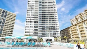 A high-rise hotel with a swimming pool area featuring sun loungers and umbrellas. - private balcony ON THE BEACH with pool 24hr front desk parking spot laundry gym (Hallandale Beach)