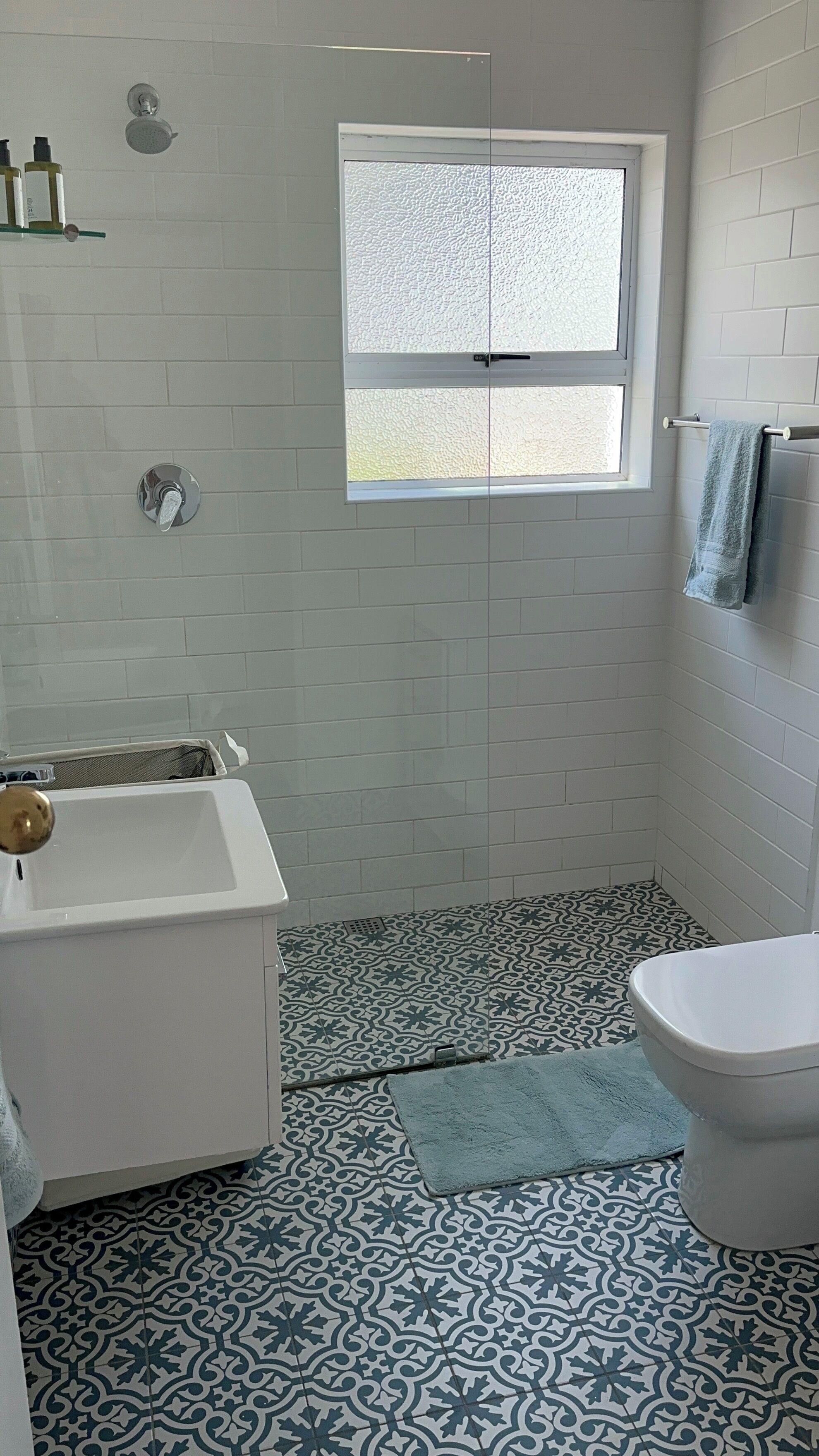 A bathroom with a bathtub, toilet, and a window.