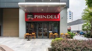 The exterior of a PHINDELI restaurant with outdoor seating. - SOHO Residence & Hotel (Ho Chi Minh City)