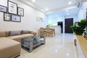 Un salón moderno con sofá, mesa de centro y cuadros en la pared.
