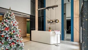 A reception area with a Christmas tree, a reception desk, and a sign that reads "SOHO RESIDENCE". - SOHO Residence & Hotel (Ho Chi Minh City)