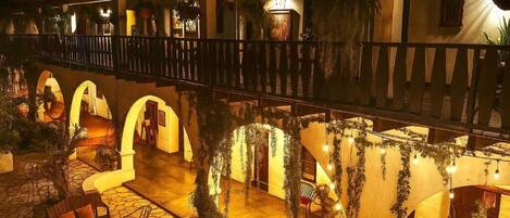 A hotel courtyard with outdoor seating and arches.