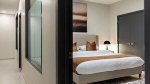 A modern bedroom with a large bed, a wardrobe, and a glass wall. - Resort Style Property 2B/2B walk to Everything! (Cleveland)