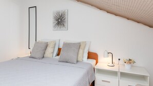 Una camera da letto con un letto, un comodino, una lampada e un elemento decorativo al muro.