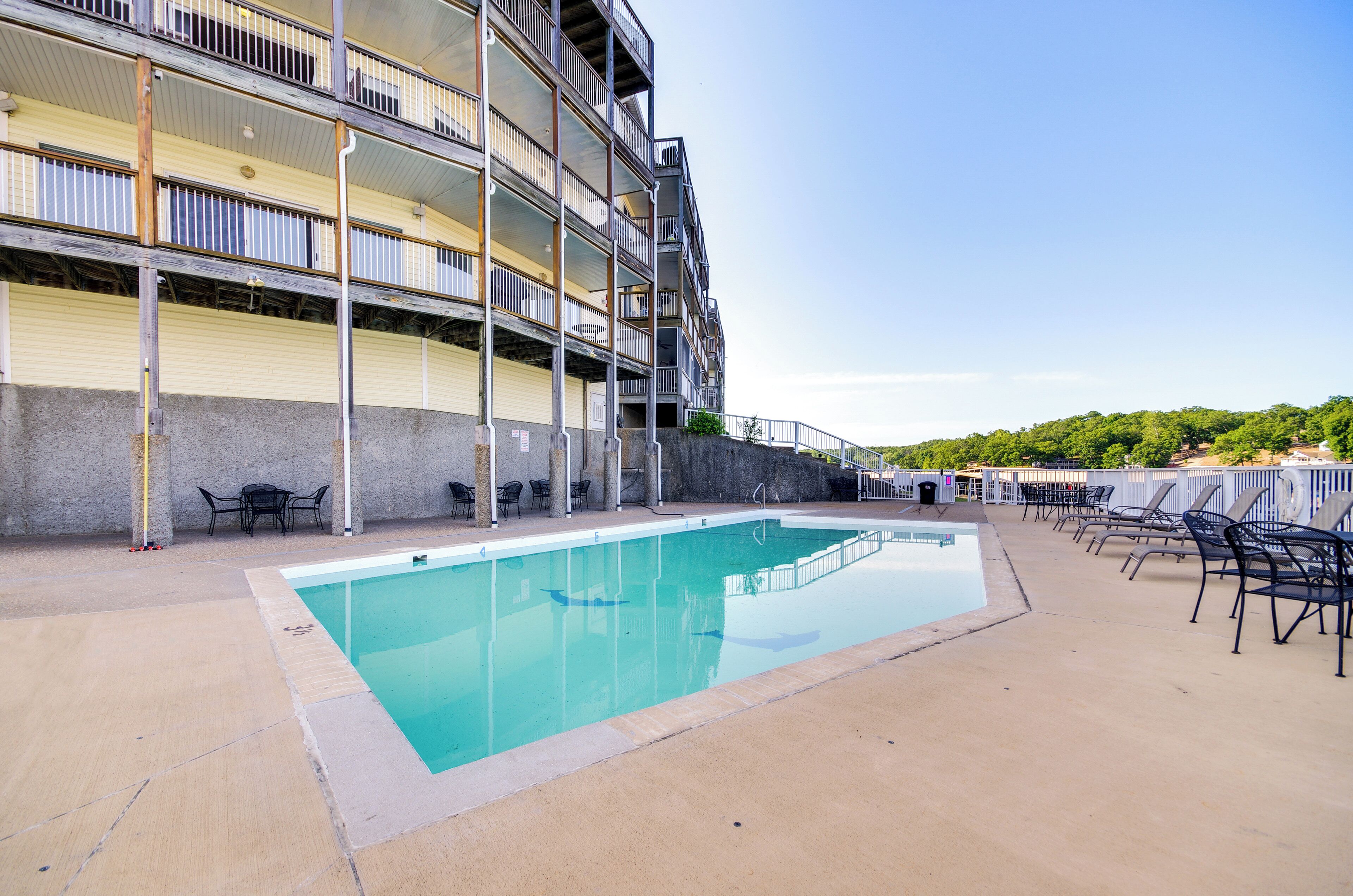 A multi-story building with a swimming pool and outdoor seating.