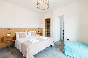 Een moderne hotelkamer met een groot bed, nachtkastjes, een kledingkast en een zitje.