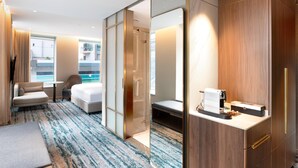 A modern hotel room with a large bed, a seating area, a shower, and a kitchenette. - Doubletree By Hilton Auckland Albert Street (Auckland)