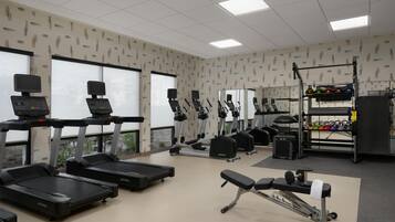 A gym with treadmills, elliptical machines, and weightlifting equipment.