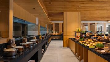 A modern kitchen with a long counter, various food items, and a wooden ceiling.