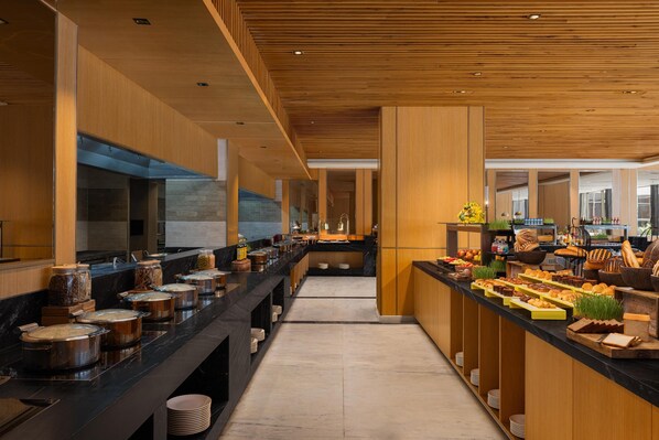 Una cocina moderna con una encimera larga, diversos alimentos y techo de madera.