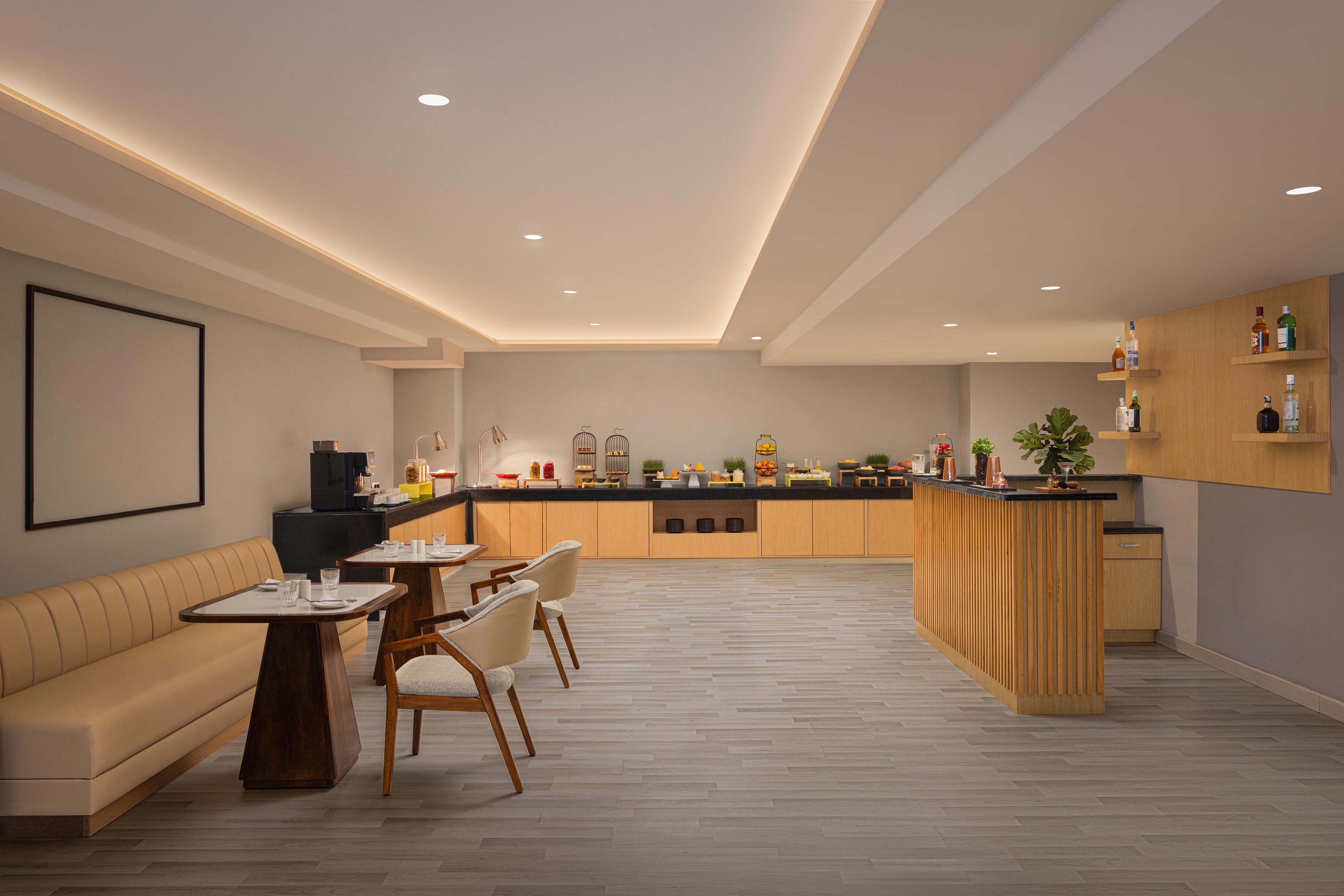 A modern kitchen with wooden cabinets, a dining area with a sofa and chairs, and a kitchen island.