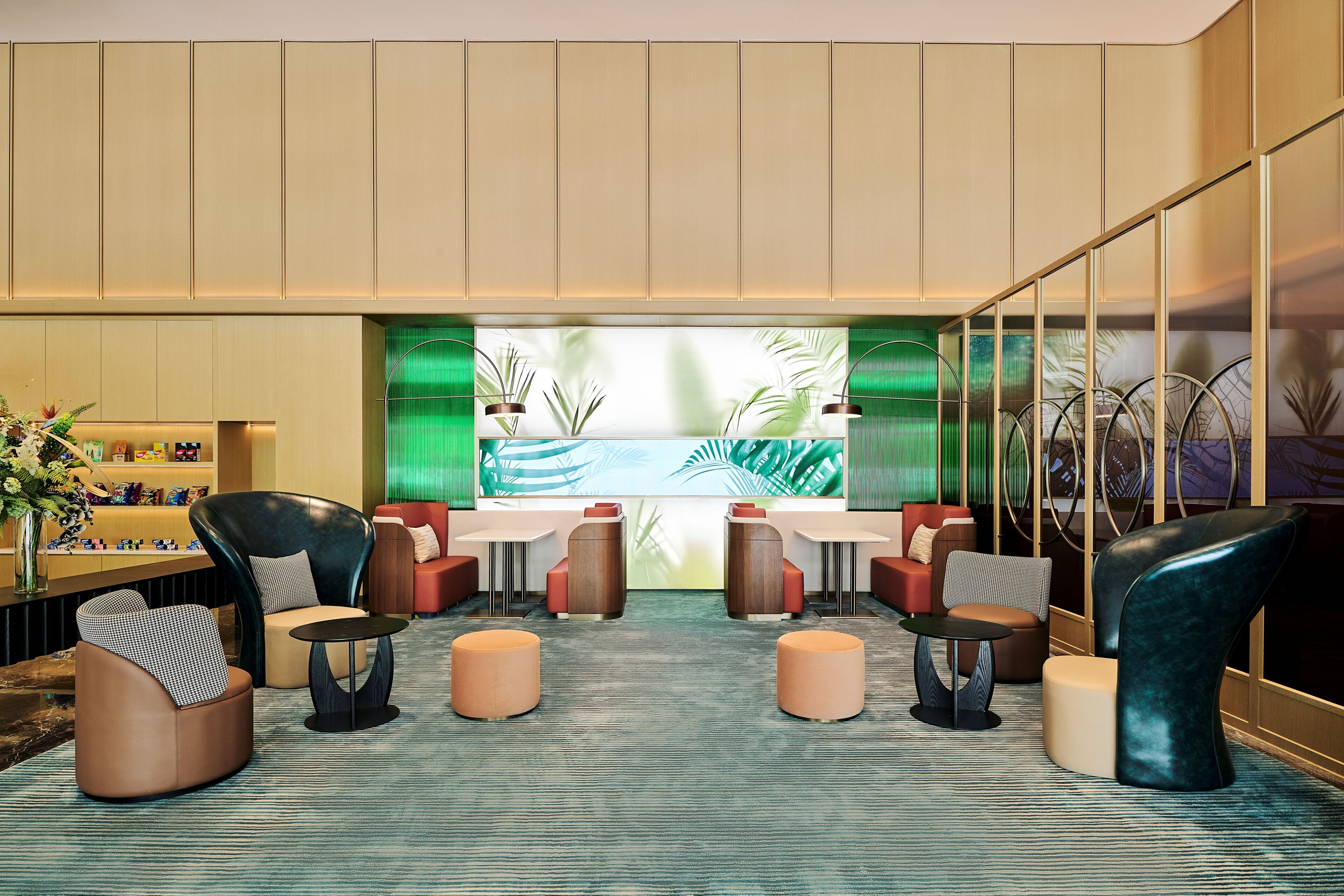 A modern lobby with seating arrangements, a reception desk, and a large wall mural.