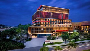 Un hotel moderno a più piani, con un ingresso ben visibile e una facciata luminosa.