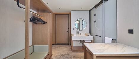 A modern bathroom with a wooden vanity, a round mirror, and a towel rack.