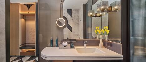 Un bagno moderno con uno specchio grande, un mobile lavabo e un porta asciugamani.