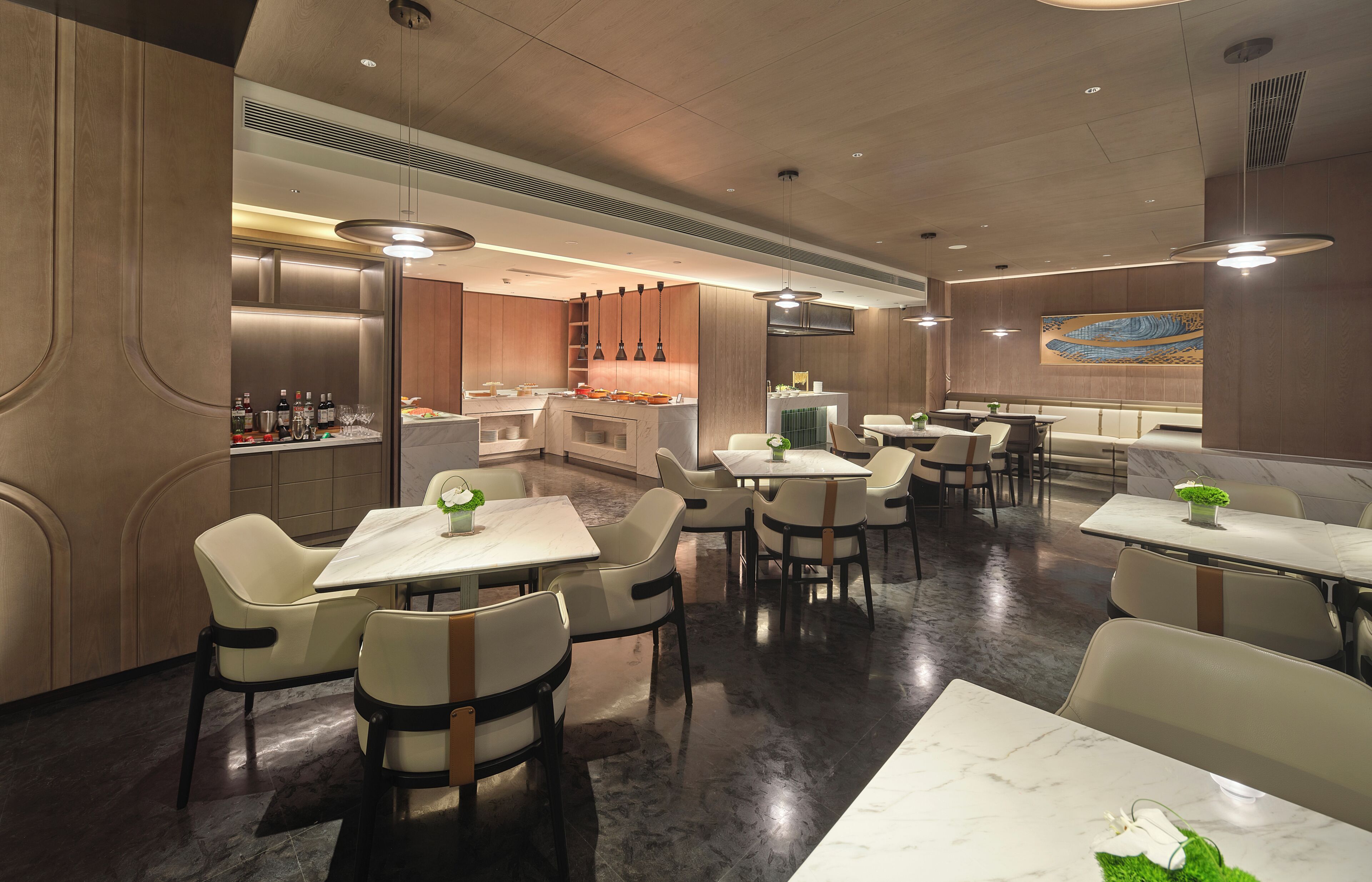 A modern restaurant with a bar area, multiple dining tables, and chairs.