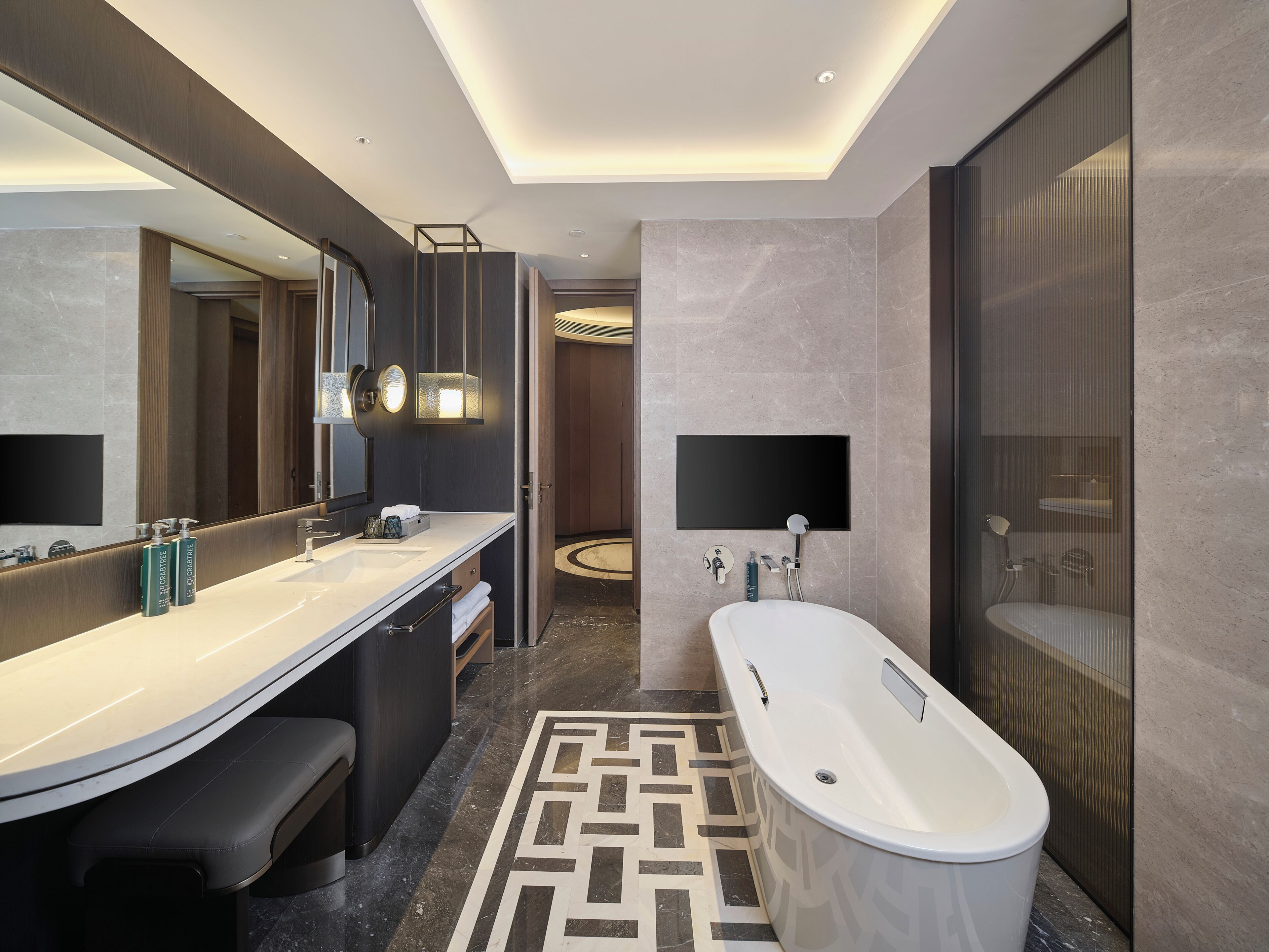 A modern bathroom with a large bathtub, a vanity with a mirror, and a separate shower area.