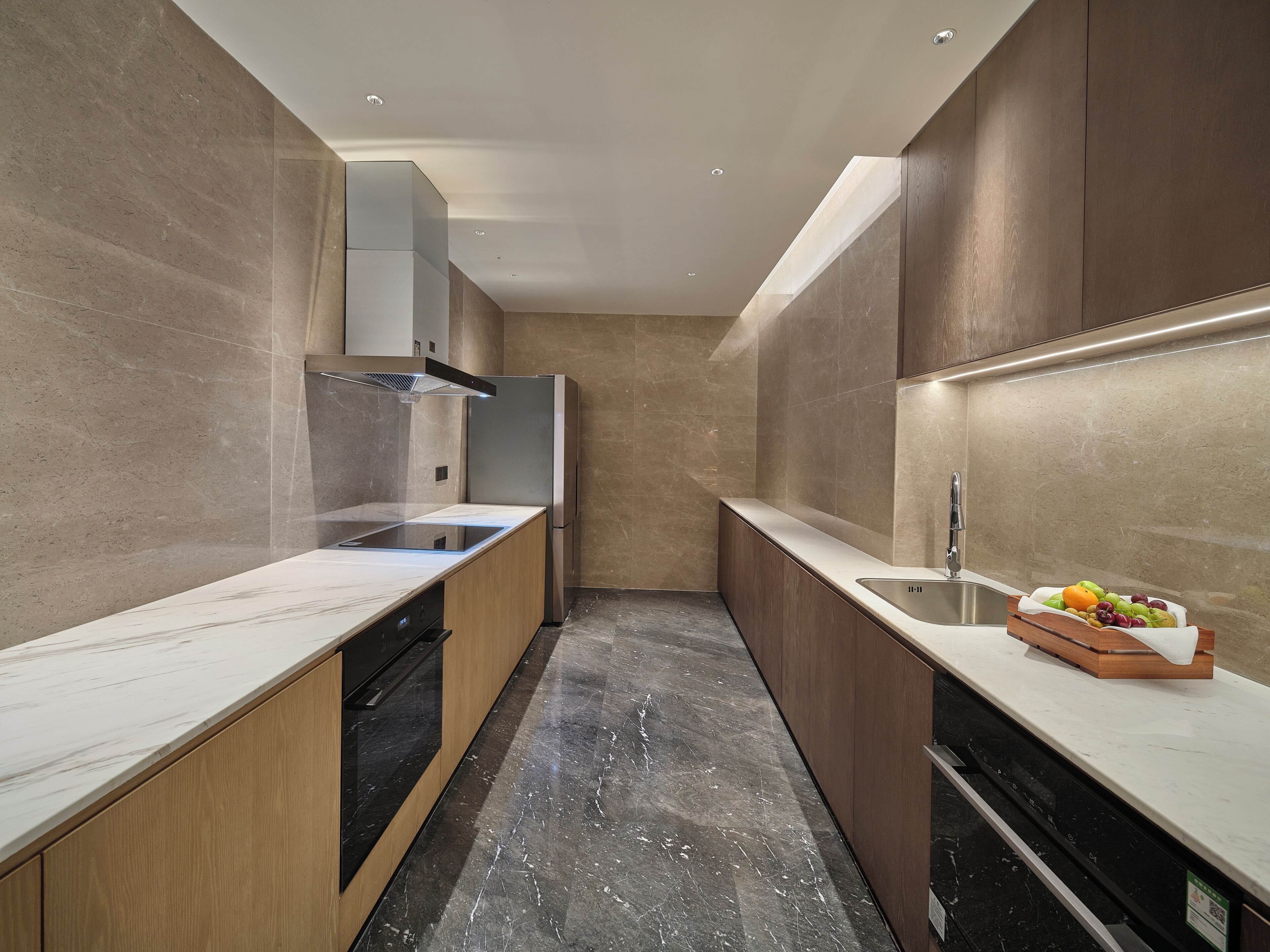 A modern kitchen with a built-in stove, a sink, and a compact refrigerator.