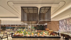 A hotel lobby with a central buffet area, seating arrangements, and a modern design. - Hilton Guangzhou Baiyun Airport Terminal 3 (Guangzhou)
