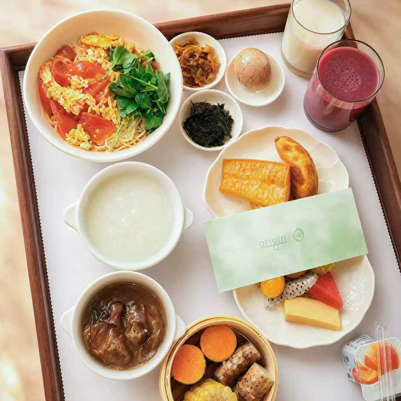 Una bandeja con diversos alimentos para el desayuno, como huevos revueltos, tostadas y una variedad de acompañamientos.
