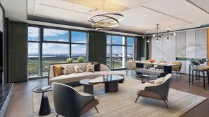 A modern hotel lobby with a large sofa, armchairs, a dining area, and large windows offering a city view. - Doubletree By Hilton Zhengzhou Airport Aerotropolis (Zhengzhou)