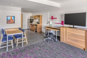 Eine moderne Küche mit Holzausstattung, einer Mikrowelle und einem Spülbecken.
