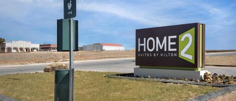 A sign for 'HOME 2 Suites by Hilton' with a pet pit stop sign nearby.