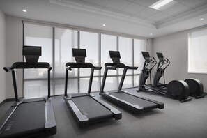 A gym with four treadmills, two elliptical machines, and a set of dumbbells. - Home2 Suites By Hilton Big Spring (Big Spring)