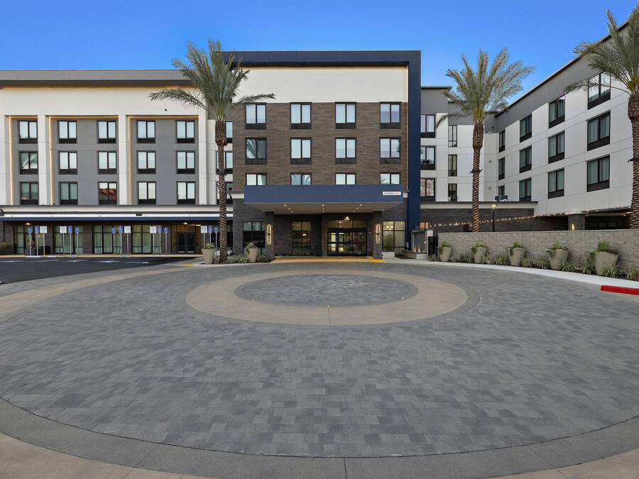 Ein modernes Hotel mit kreisförmigem Zugangsbereich, mehreren Etagen und einer Fahnenstange mit der US-amerikanischen Flagge.