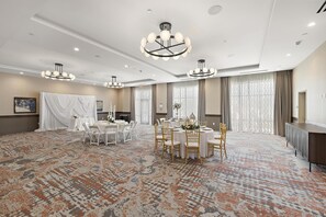 A spacious hotel dining area with round tables, white chairs, and a patterned carpet. - Hampton Inn By Hilton Ontario Airport (Ontario)