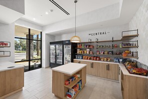 Un bar de aperitivos moderno y bien iluminado con una variedad de productos envaselados y un mostrador refrigerado.