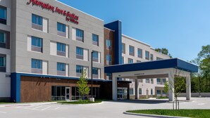 A Hampton Inn & Suites by Hilton hotel with a modern facade, multiple windows, and a covered entrance. - Hampton Inn & Suites Cadillac (Cadillac)