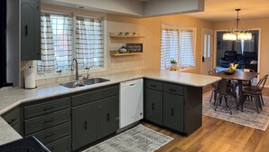 Una cocina moderna con lavavajillas incorporado, armarios oscuros y una isla grande.