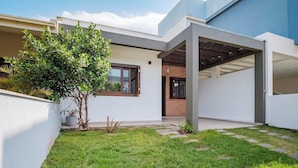 A modern house with a covered patio, a small garden, and a brick entrance. - House w/ 3 Bedrooms and Barbecue Lpb0000 (Garopaba)