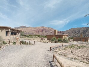 A desert landscape with a stone building and a wooden fence.