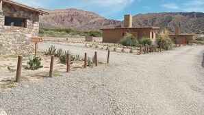 A rustic building with stone walls and a gravel driveway. - Cabañas La Nochera (Tilcara)