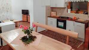 A compact kitchen with a dining area, a television, and a small refrigerator. - 2 bedroom nice apartment in Mrkopalj (Mrkopalj)