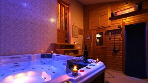 Interior de una cabaña de madera con jacuzzi, paredes de madera y puerta de madera.