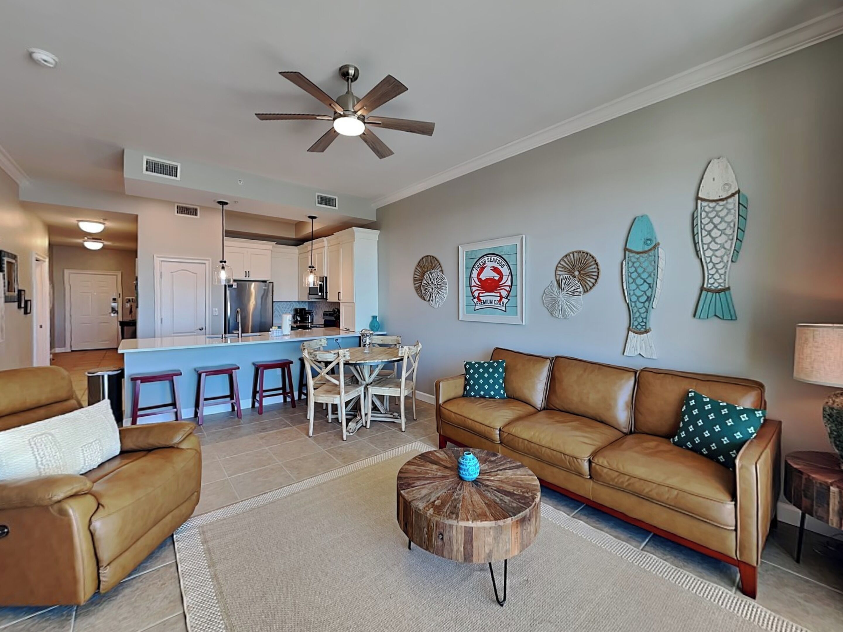 A modern living room with a brown leather sofa, a wooden coffee table, and a dining area with a white table and chairs.