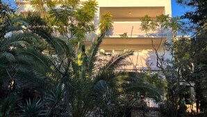 A multi-story building with balconies, surrounded by dense tropical foliage. - Apartment in Novalja (127) (Novalja)