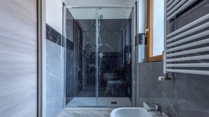 A modern bathroom with a glass-enclosed shower, a white sink, and marble flooring. - Il Piccolo Borghetto - Guest House Stazione Tiburtina (Roma)
