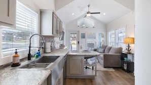 Una cucina moderna con isola centrale, pensili integrati e vista sull'area living.