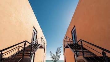 A view of a building with two staircases leading to a window, with a clear sky above.